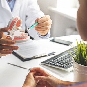 A patient talking to their dentist at a dental implant consultation
