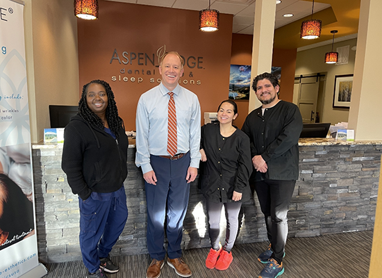 Dr. Waite and other dental team members at front desk in waiting room