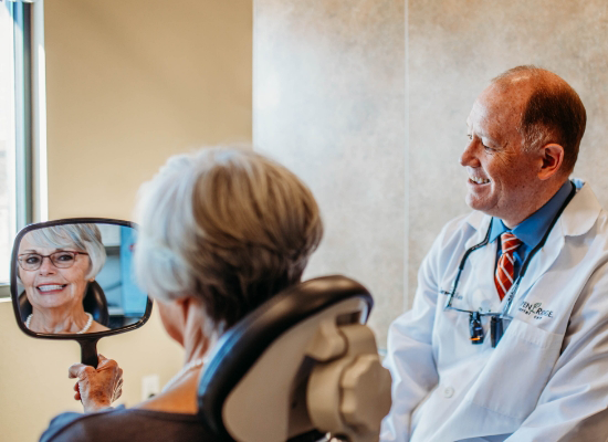 Dentist watching as dental patient checks teeth
