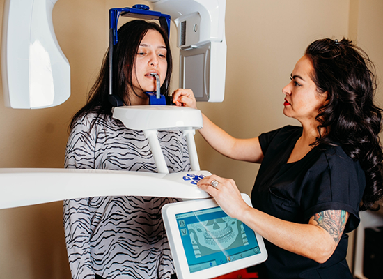 Dental team member about to use cone beam scanner on female patient