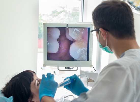 Dentist checking patient's teeth with intraoral camera