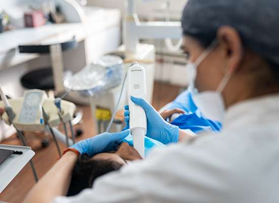 Female dentist holding wand for digital impression system